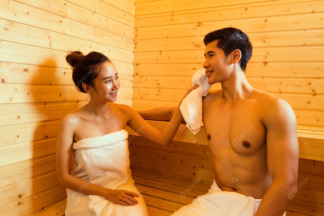 Casal jovem asiático sentados na sala de spa da sauna com vapor quente relaxando