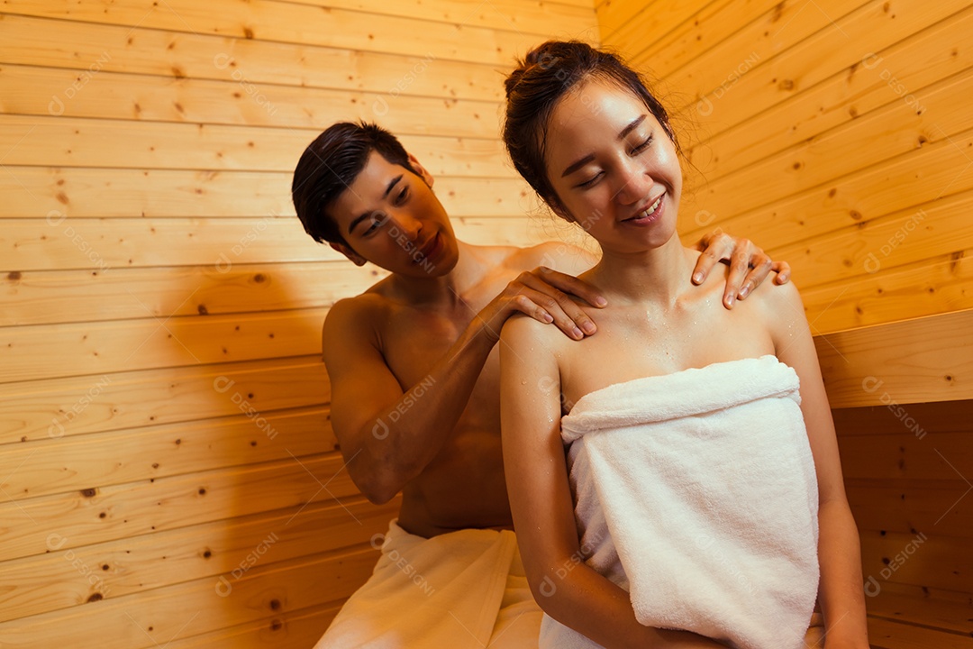Casal jovem asiático sentados na sala de spa da sauna com vapor quente relaxando