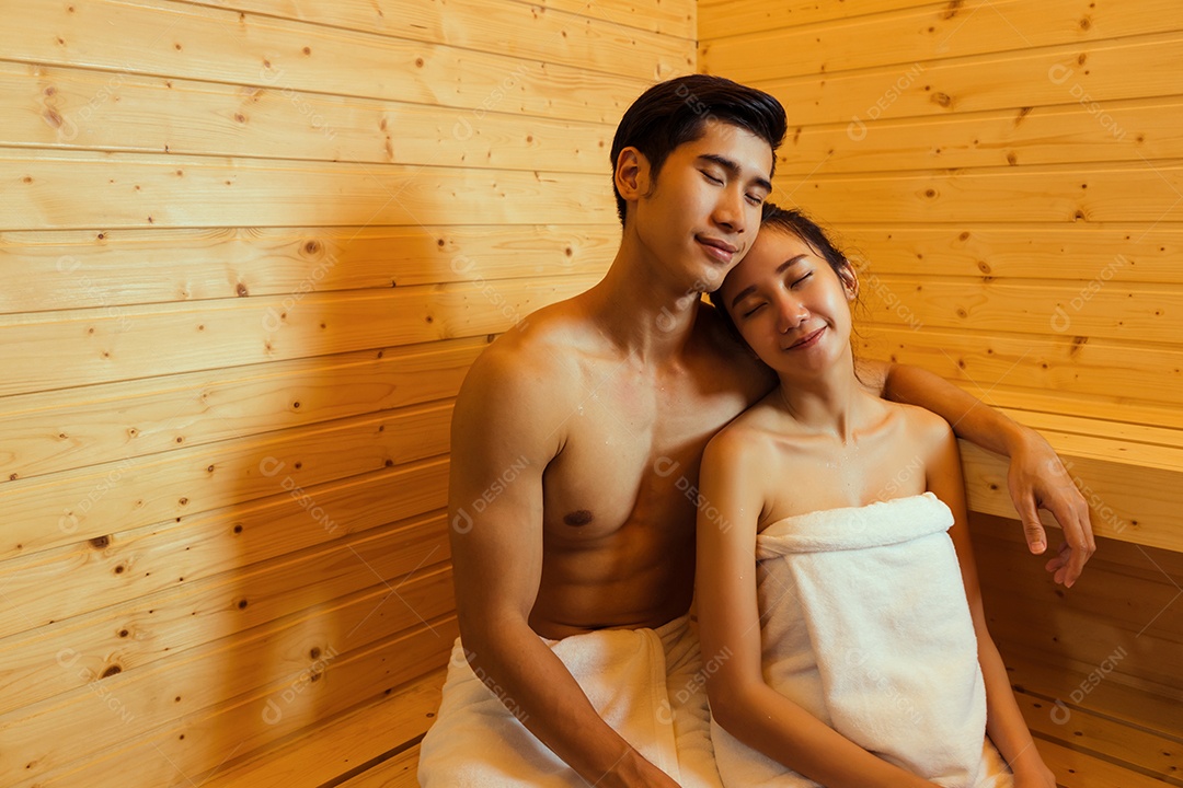 Casal jovem asiático sentados na sala de spa da sauna com vapor quente relaxando