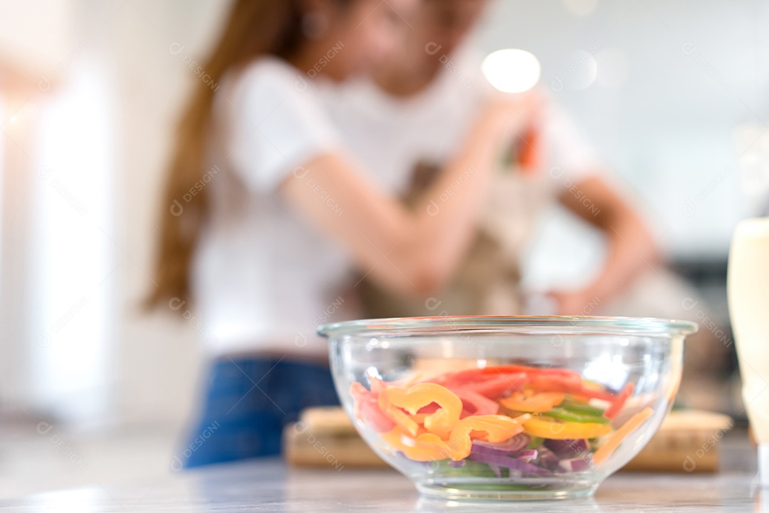 Casal jovem asiático e mulher juntos cortando fatias de legumes fazendo cada salada e comida para o menu de jantar