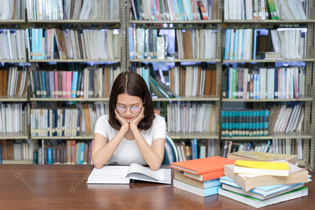 Jovens seriamente com seu exame e lendo livro na biblioteca