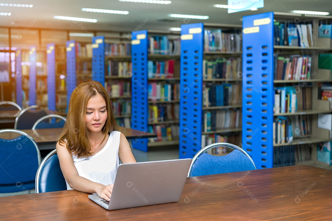 Menina jovem estudante asiática usando o projeto de trabalho do computador portátil