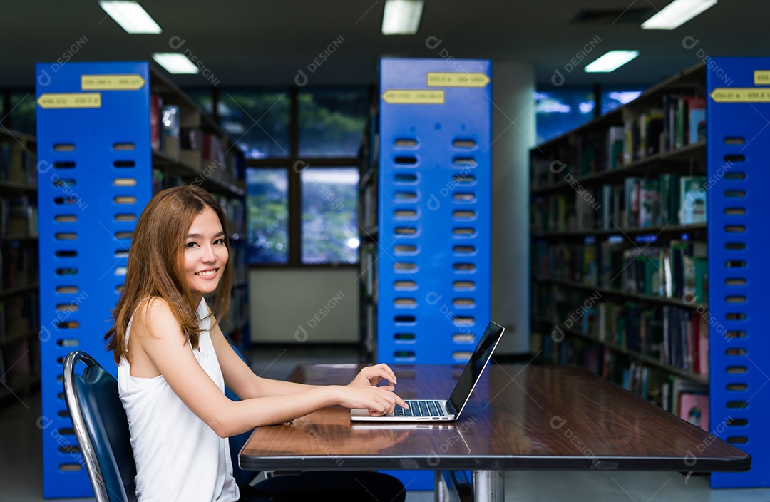 Menina jovem estudante asiática usando o projeto de trabalho do computador portátil