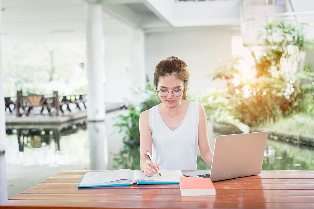 Jovem estudante com computador portátil feliz e divertido