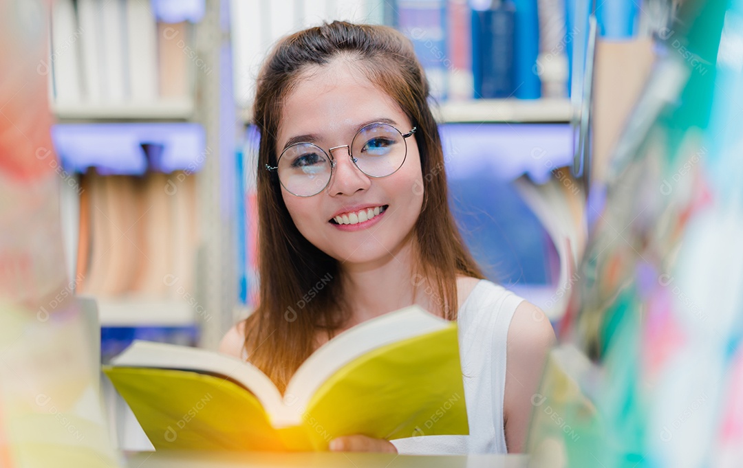 Alunas com o livro de pastas escolares na biblioteca da Universidade