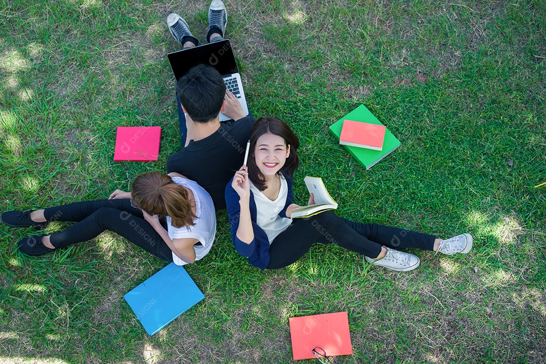 Alunos jovens estudam juntos lendo livro na universidade