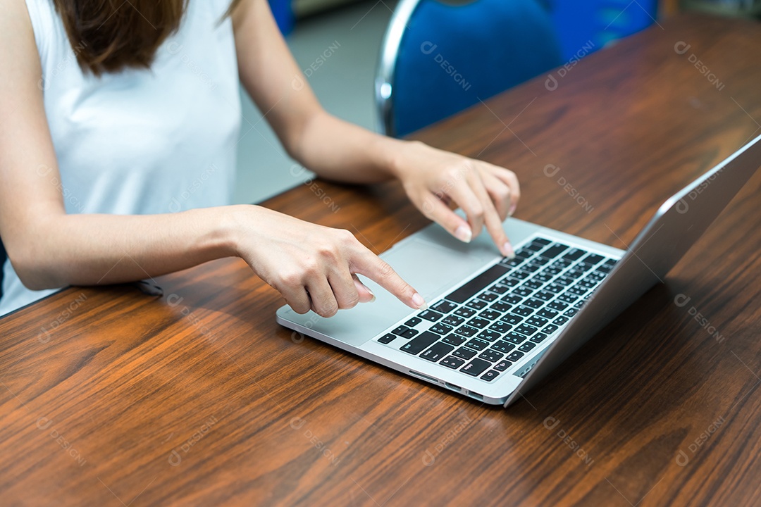 Menina usando laptop na mesa de madeira na sala de aula