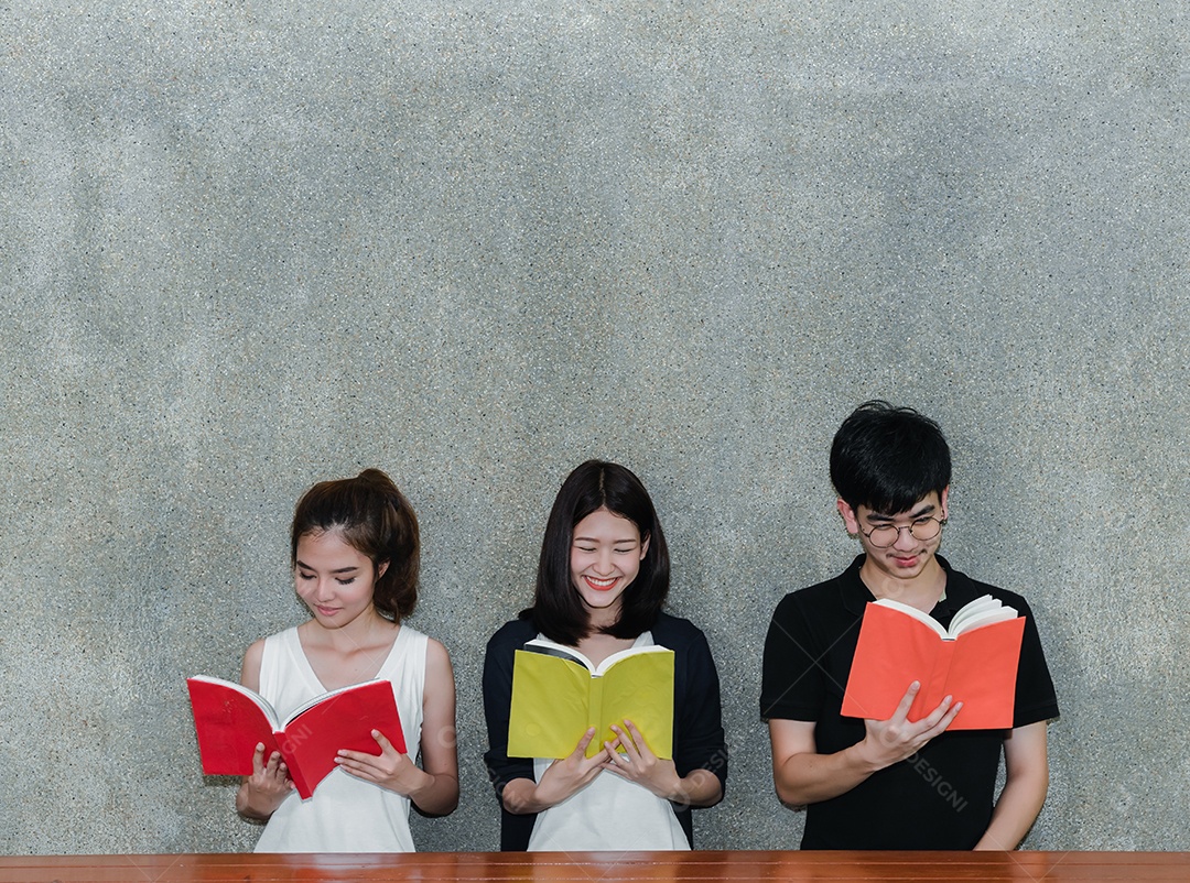 Grupo de jovens estudantes sorrindo com pastas Livro e computador portátil