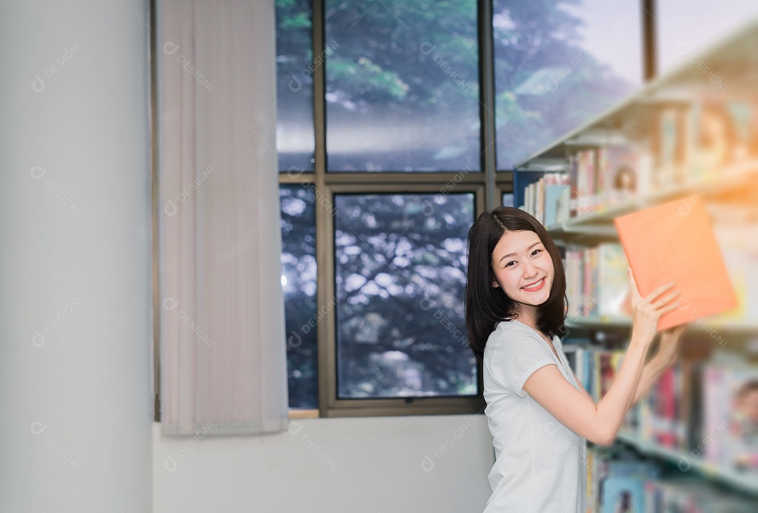 Jovem estudante lendo livro na biblioteca