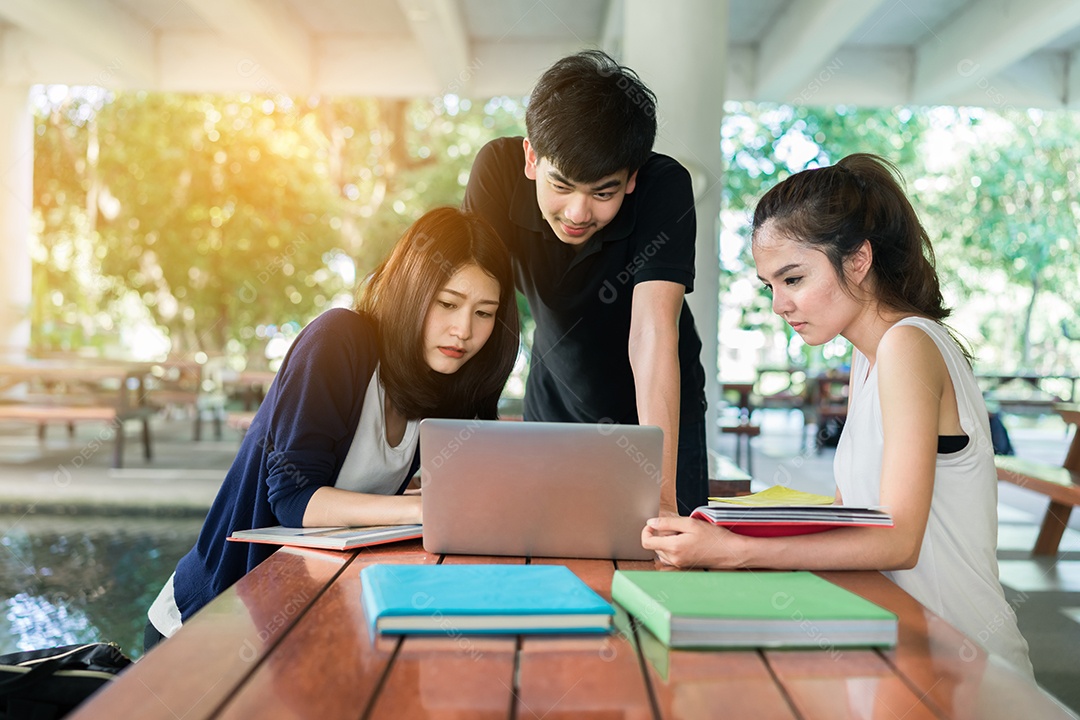 Grupo de Jovens Estudantes Consulta com Pastas Escolares, Computador Portátil na Universidade