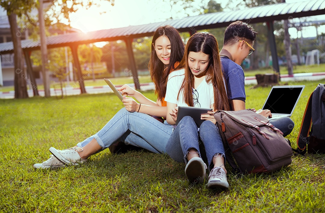 Jovens estudantes juntos estudando com livros e computador portátil