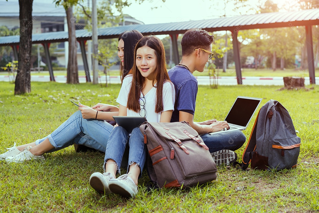 Jovens estudantes juntos estudando com livros e computador portátil
