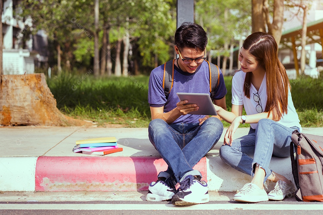 Estudantes adolescente homem asiático e mulher juntos usando computador portátil