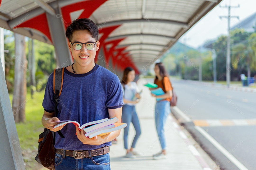 Estudantes asiáticos juntos sorrindo com livros