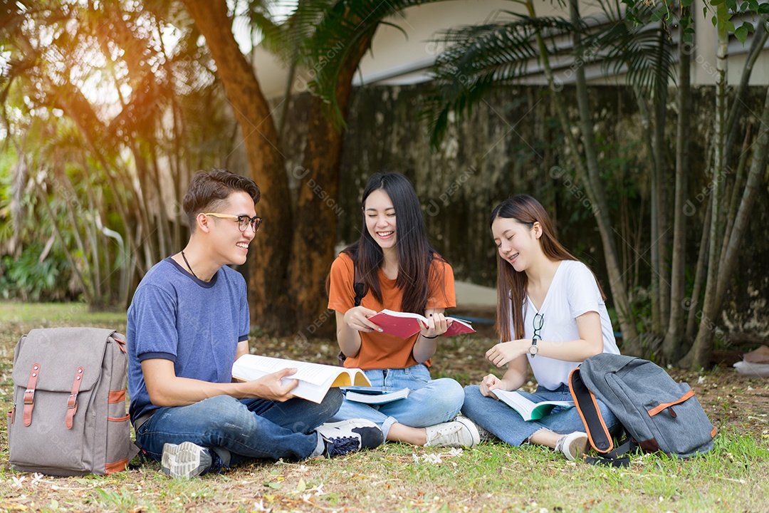 Estudantes jovens asiáticos juntos lendo estudo de livro