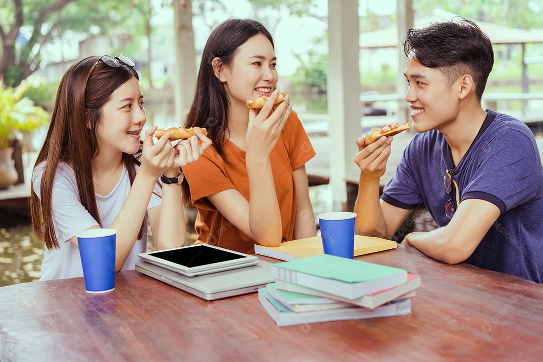 Alunos asiáticos agrupam-se comendo pizza no intervalo