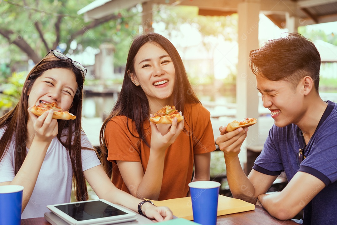 Alunos asiáticos agrupam-se comendo pizza no intervalo