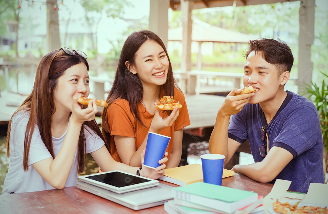 Alunos asiáticos agrupam-se comendo pizza no intervalo