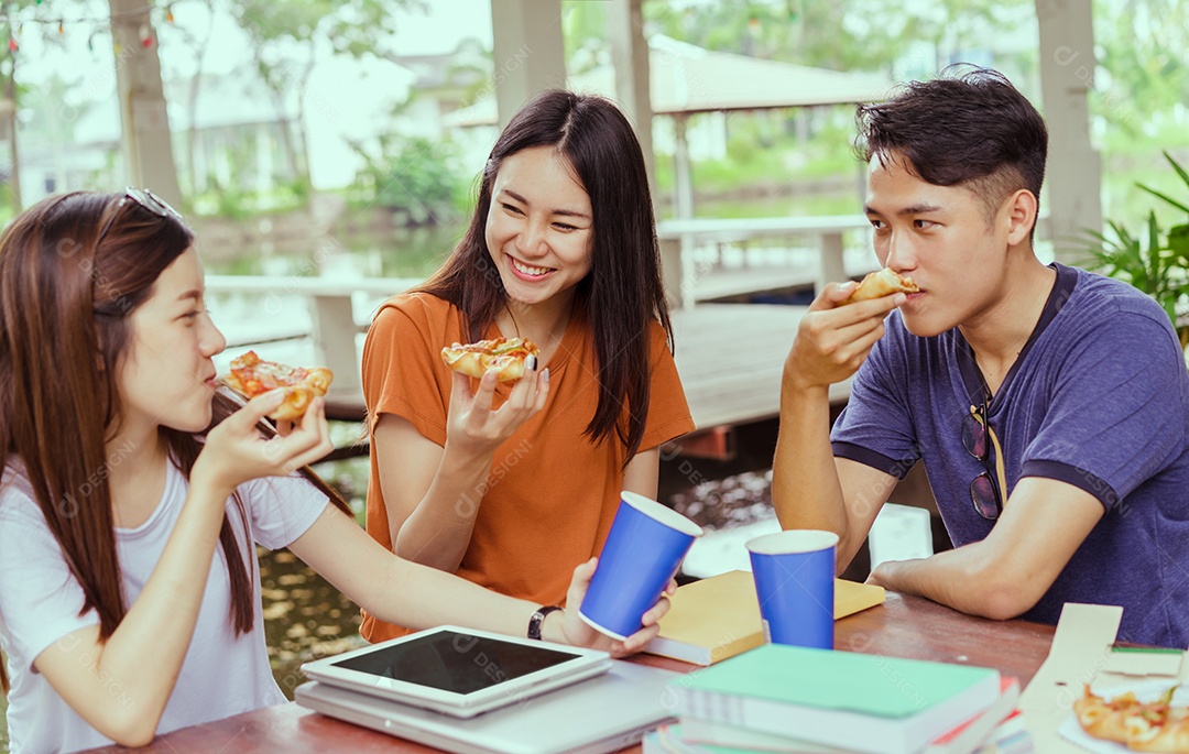 Alunos asiáticos agrupam-se comendo pizza no intervalo