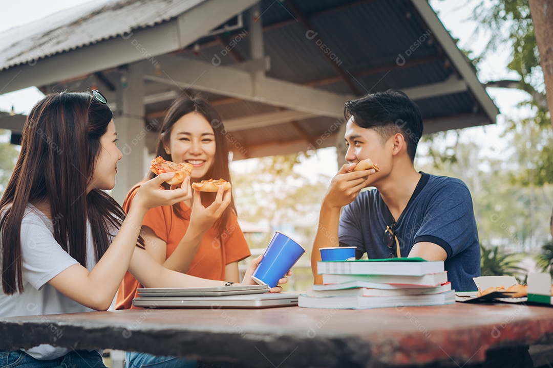 Alunos asiáticos agrupam-se comendo pizza no intervalo