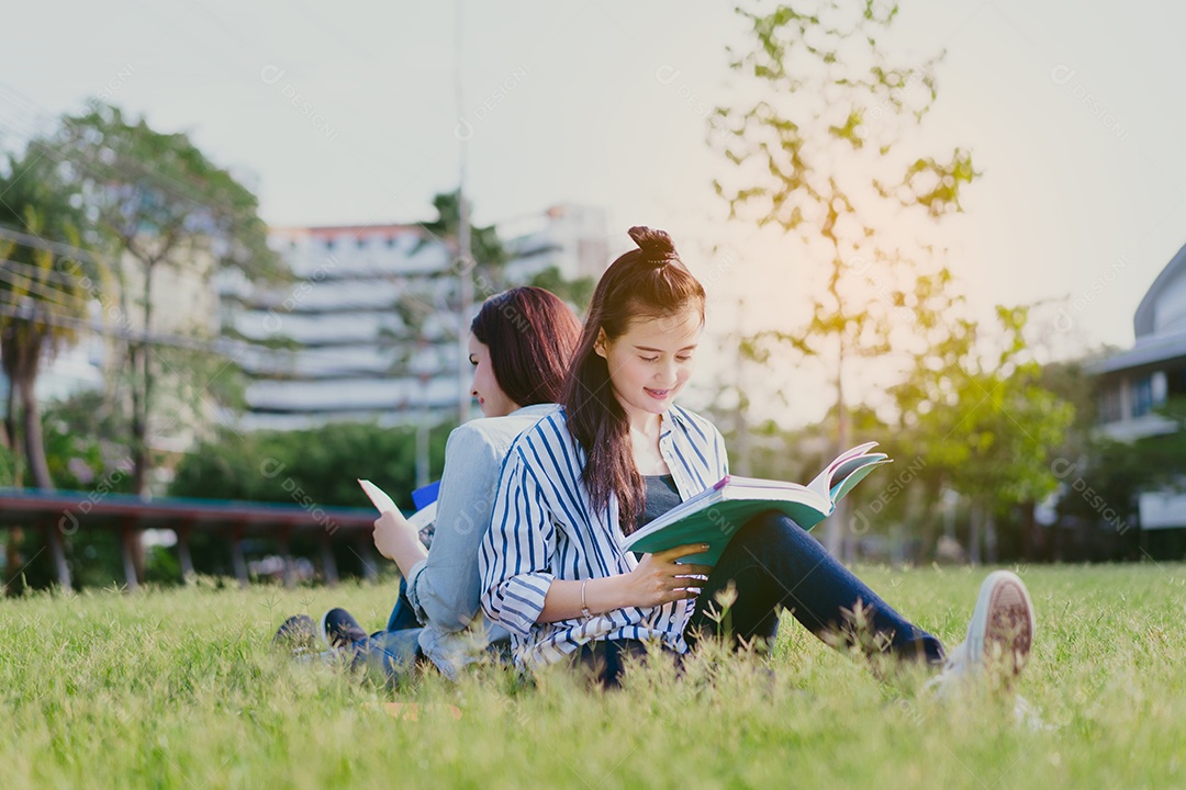 Mulheres jovens juntas estudam lendo livro na universidade