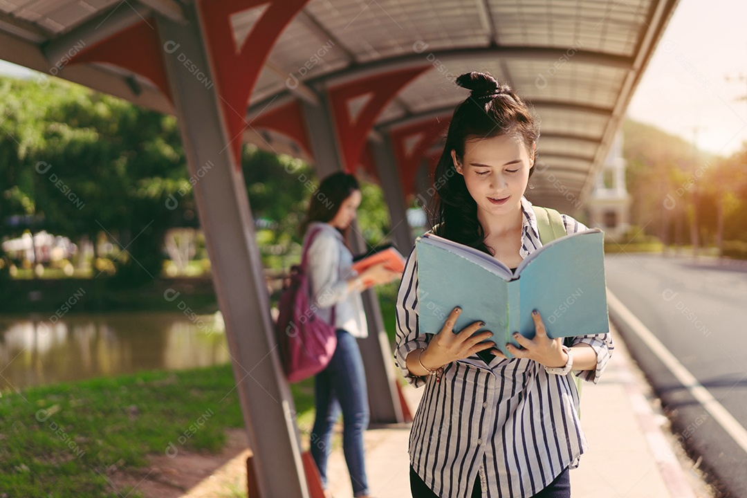 Mulheres jovens juntas estudam lendo livro na universidade