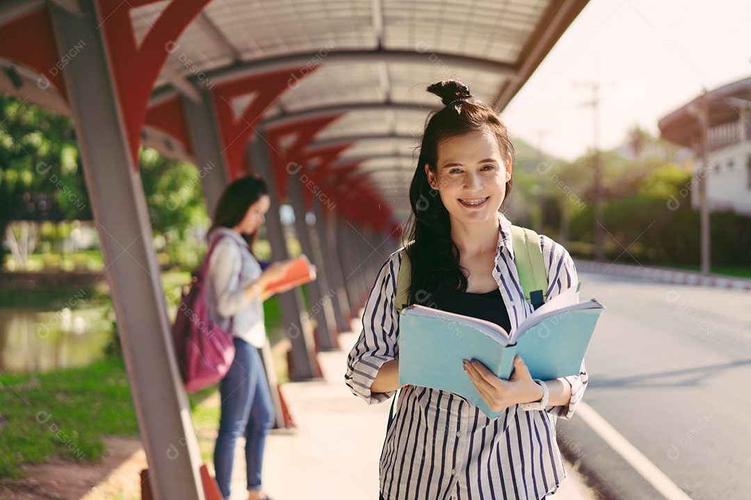 Mulheres jovens juntas estudam lendo livro na universidade