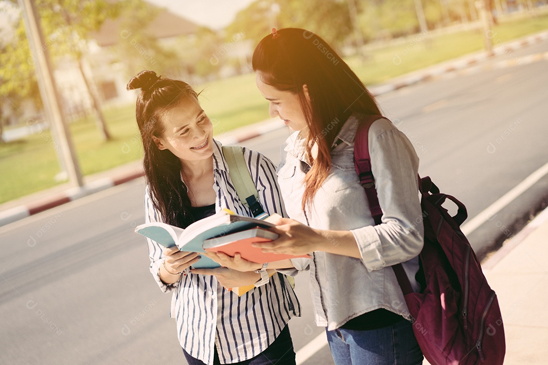 Alunos jovens estudam juntos lendo livro na universidade