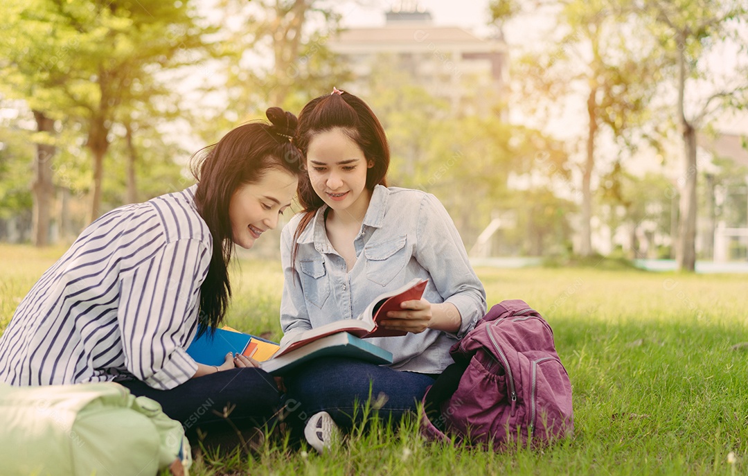 Mulheres jovens juntas estudam lendo livro na universidade