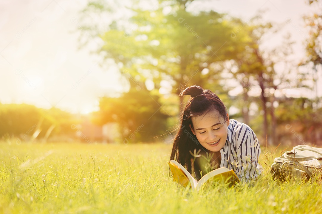 Estudante jovem lendo livro na faculdade do campus universitário