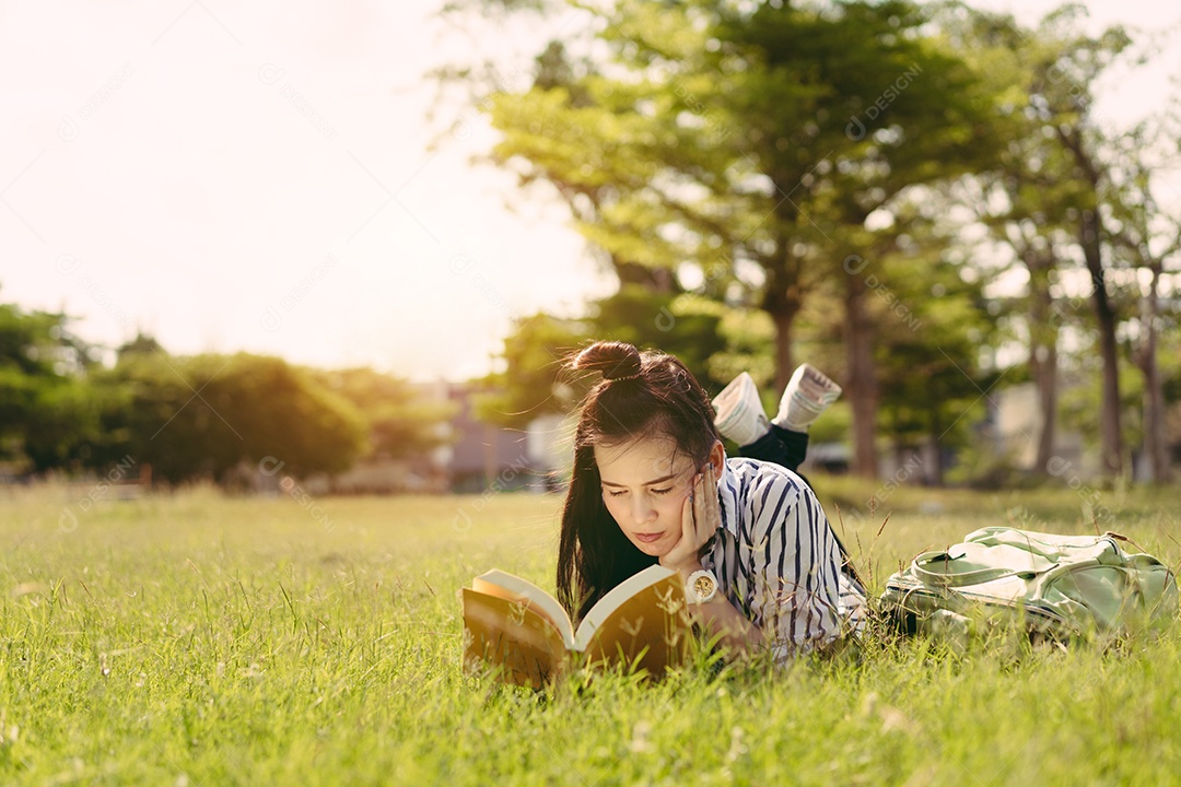 Estudante jovem lendo livro na faculdade do campus universitário