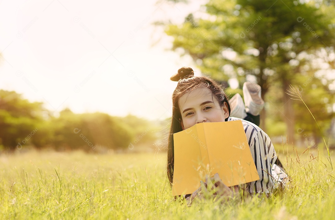 Estudante jovem lendo livro na faculdade do campus universitário