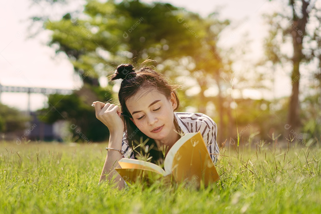 Estudante jovem lendo livro na faculdade do campus da universidade e estudando