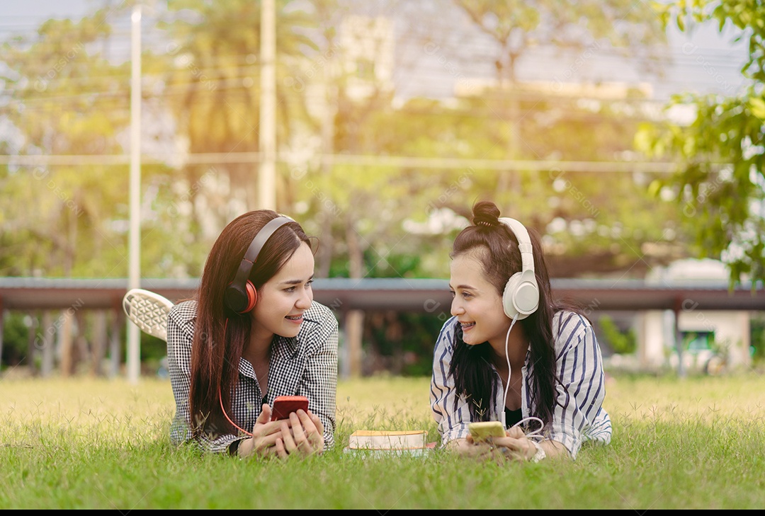 Mulheres jovens adolescentes juntas ouvindo música com fone de ouvido