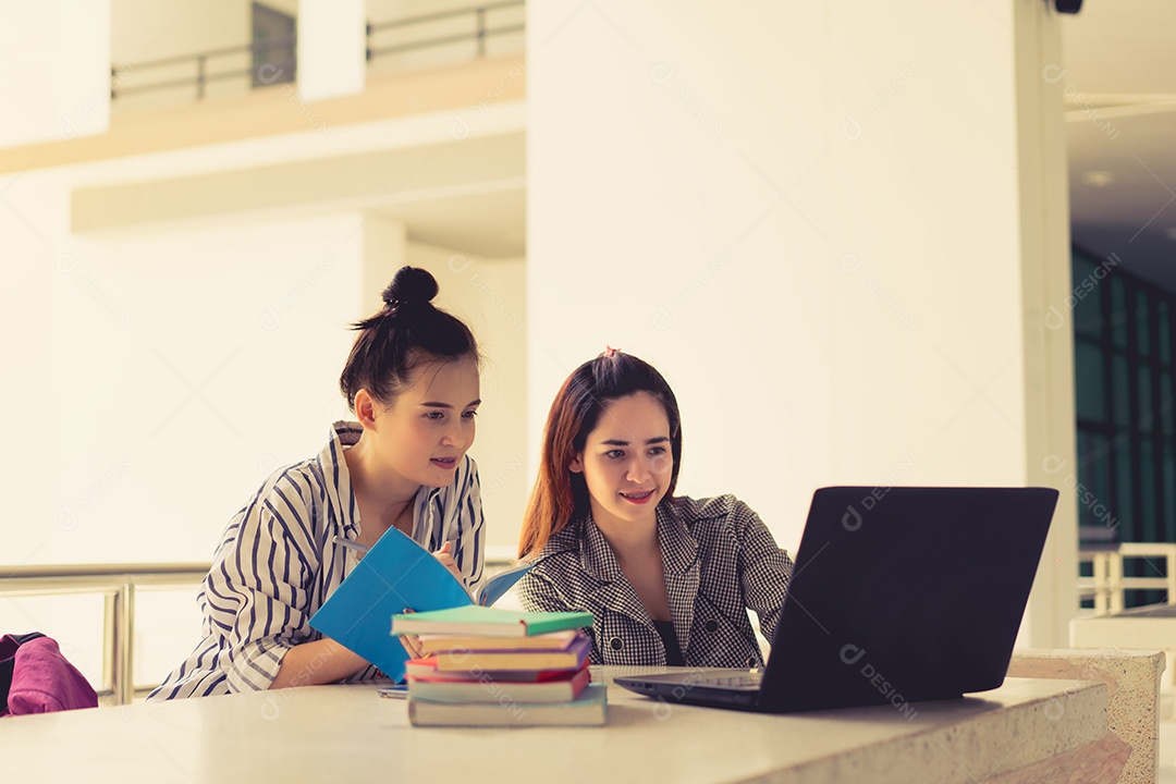 Alunos jovens estudam juntos lendo livro na universidade
