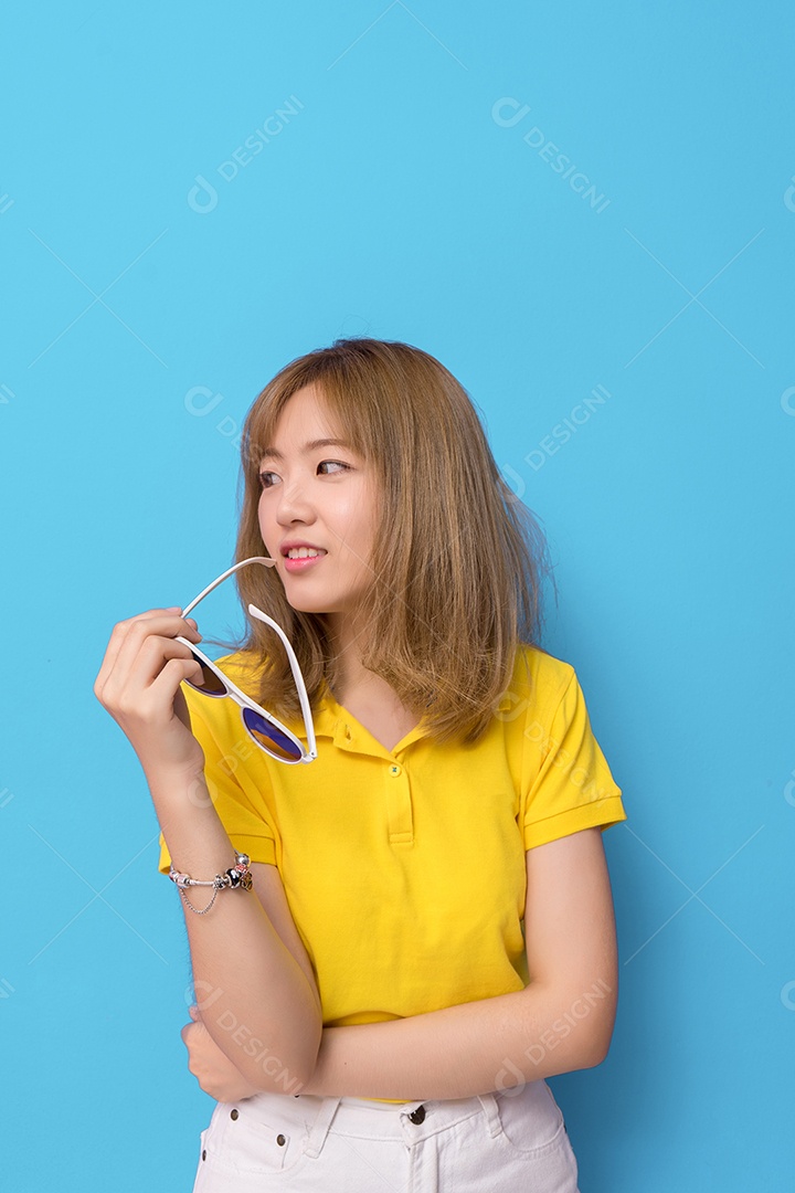 Jovem sorridente com óculos de sol e camisa amarela
