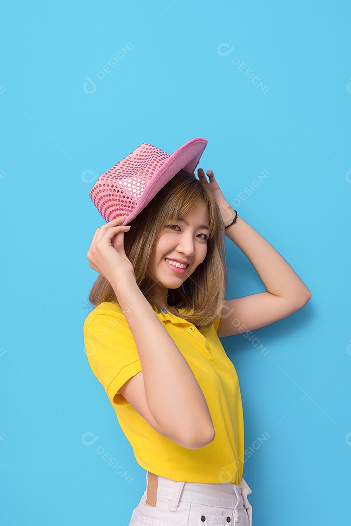Jovem sorridente com chapéu rosa e camisa amarela