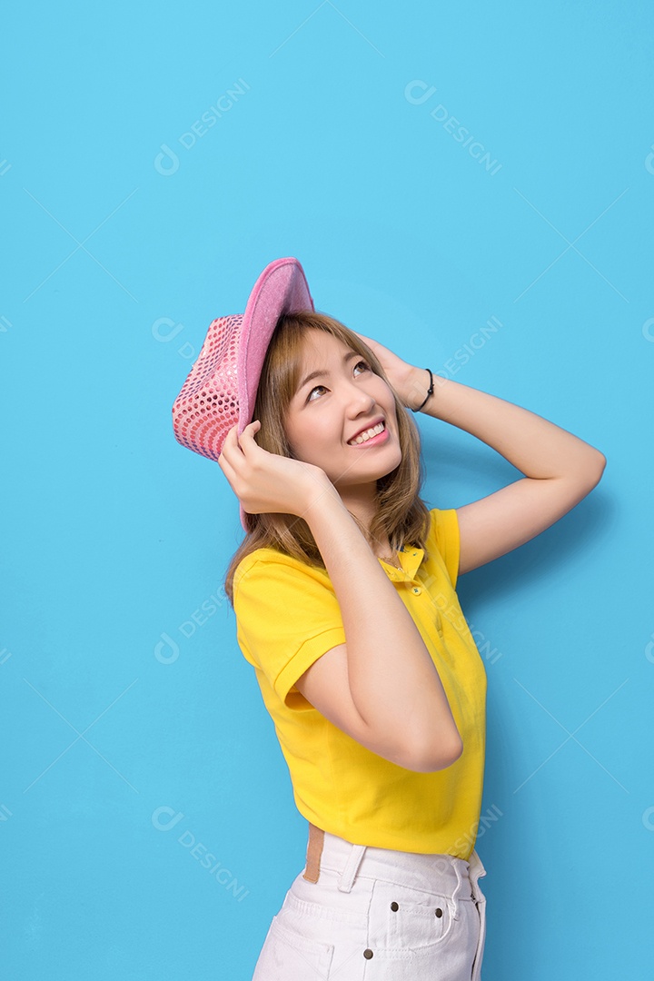 Jovem sorridente com chapéu rosa e camisa amarela