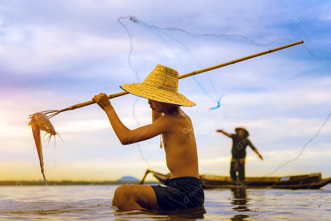 Menino pescador com captura de peixes e pescador jogando redes no barco do lago rio Tailândia