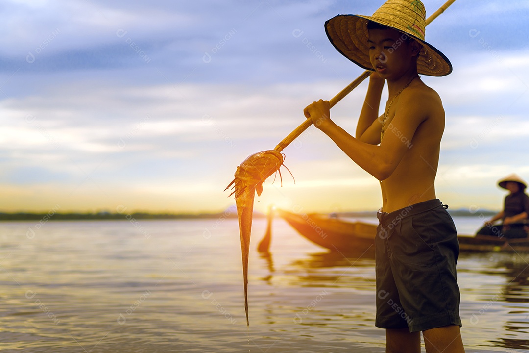 Menino pescador com captura de peixes e pescador jogando redes do barco no lago rio Tailândia