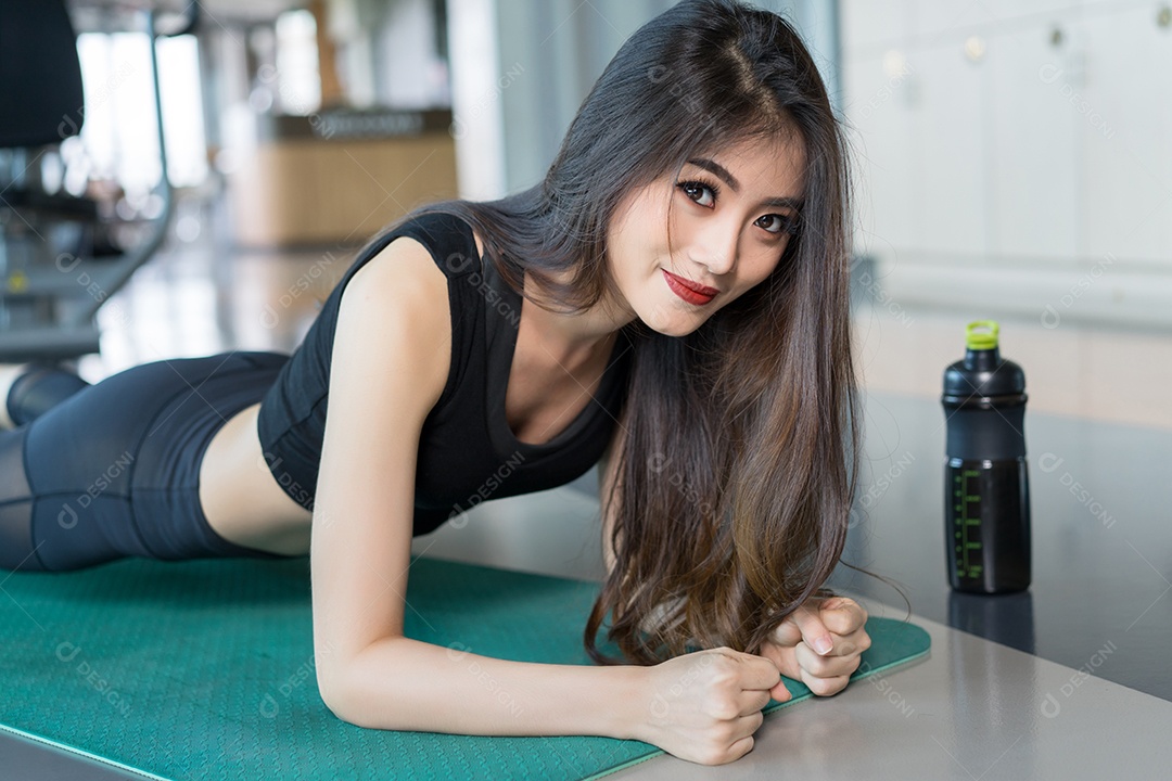 Mulher asiática esportiva fazendo prancha na aptidão de treino de ginástica