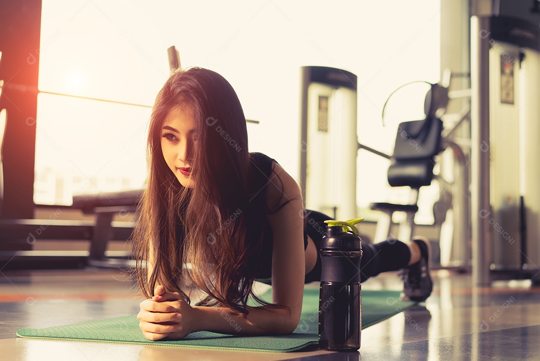 Mulher asiática esportiva fazendo prancha na aptidão de treino de ginástica