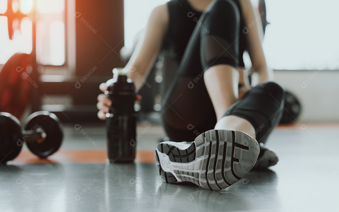 Treino de mulher na academia garrafa com shake de proteínas