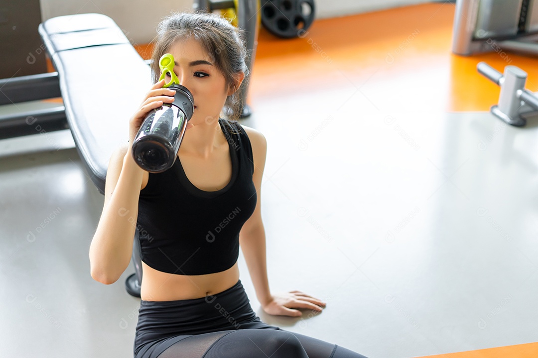 Treino de mulher na academia garrafa com shake de proteínas