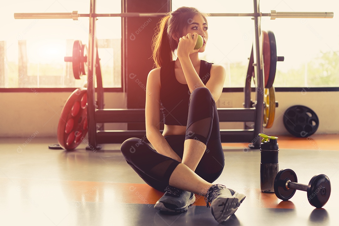 Treino de mulher na academia com fruta saudável