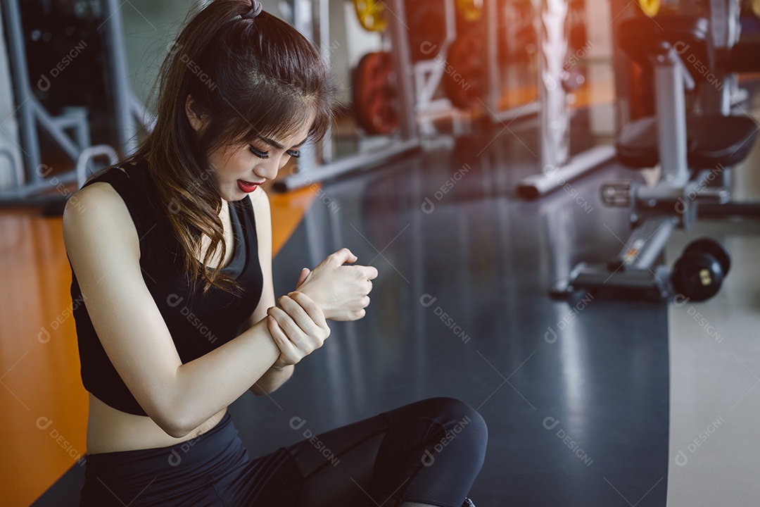 Mulher com lesão no braço em exercícios na academia