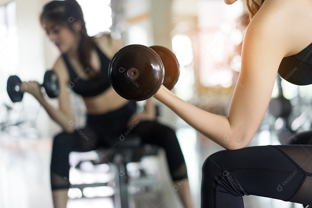Mulher jovem asiática segurando halteres para exercícios