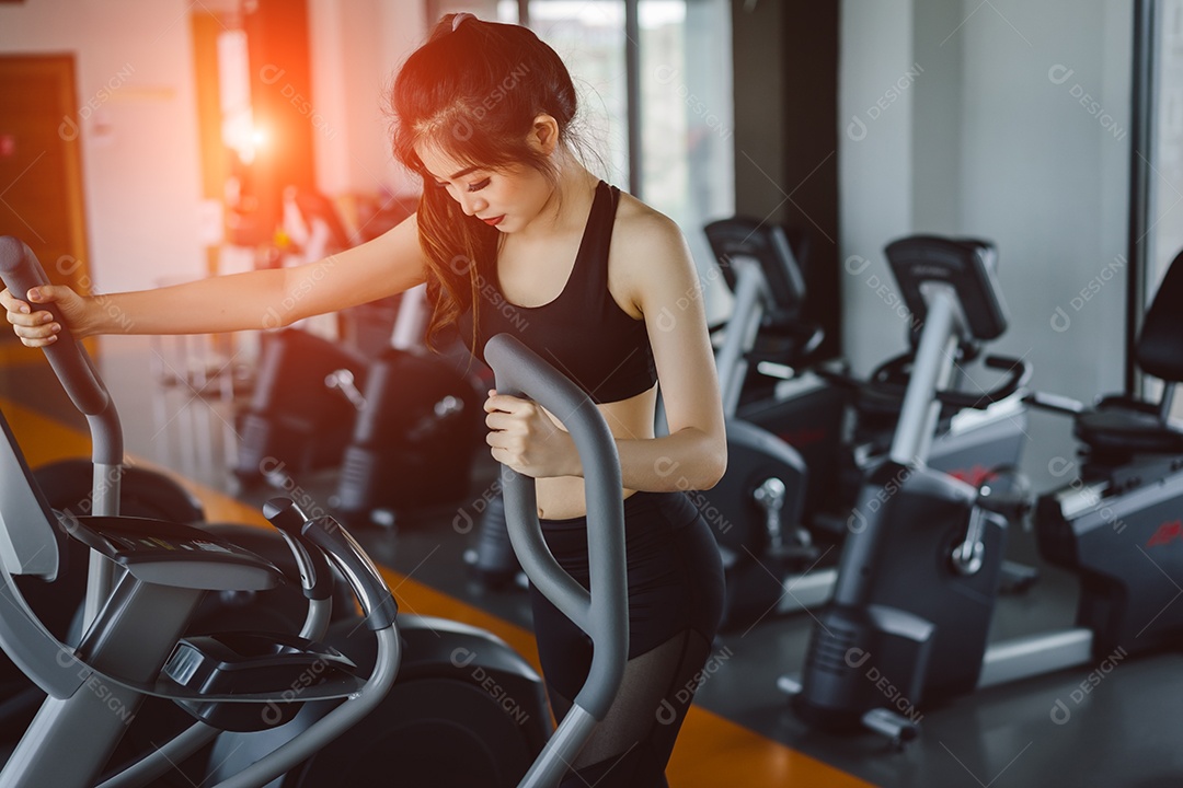 Treino da mulher na bicicleta ergométrica na academia fitness