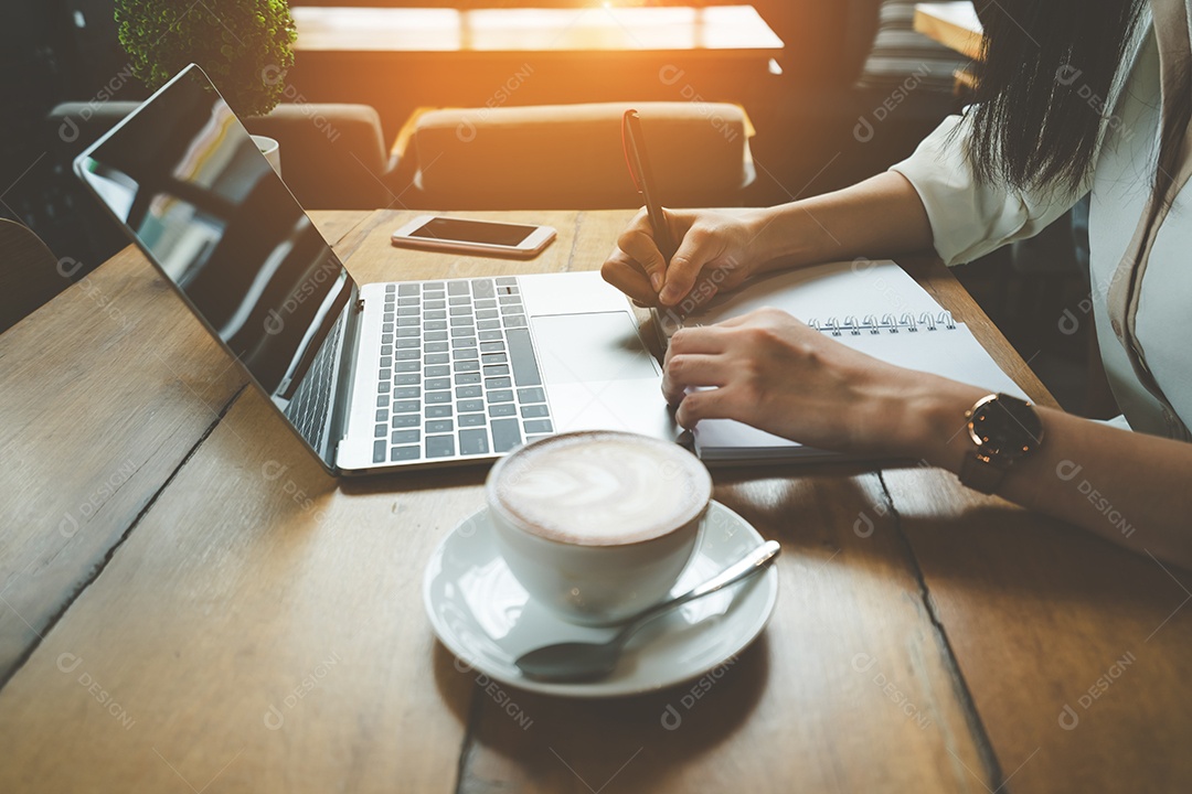 Mulher asiática freelancer trabalhando e escrevendo nota com computador portátil digital