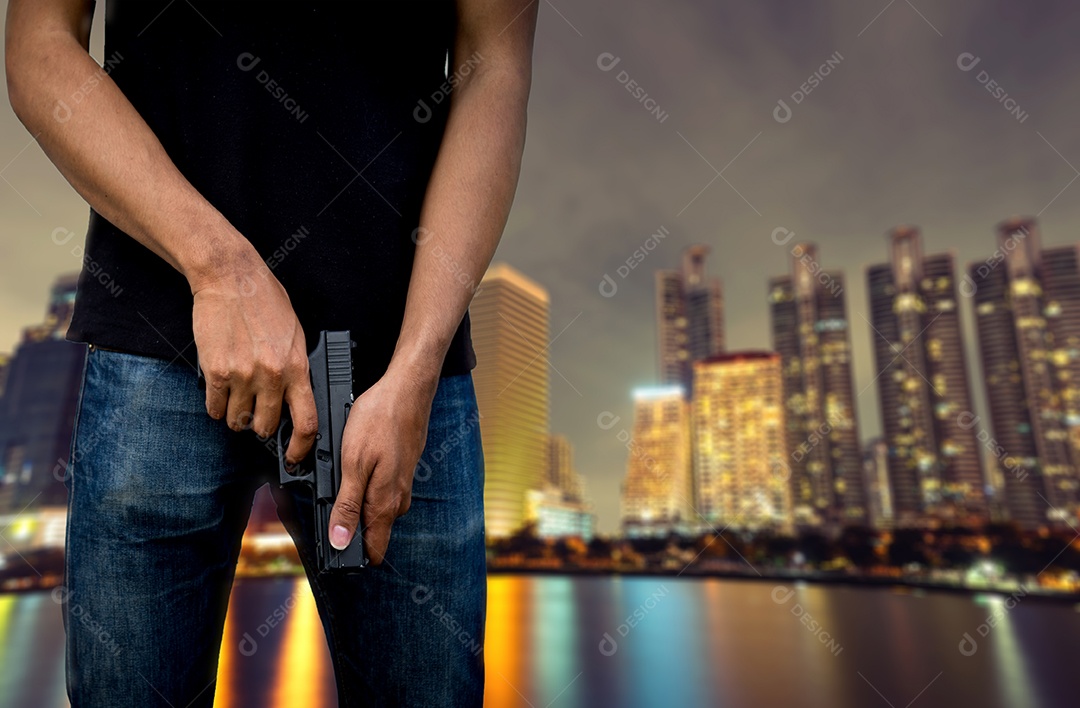 Homem segurando arma para assassino na cidade à noite
